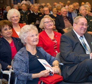 group of older white people sitting at a conference 
