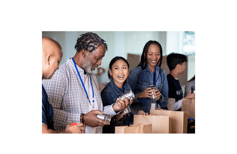 Diverse group of volunteers package groceries for community at food bank