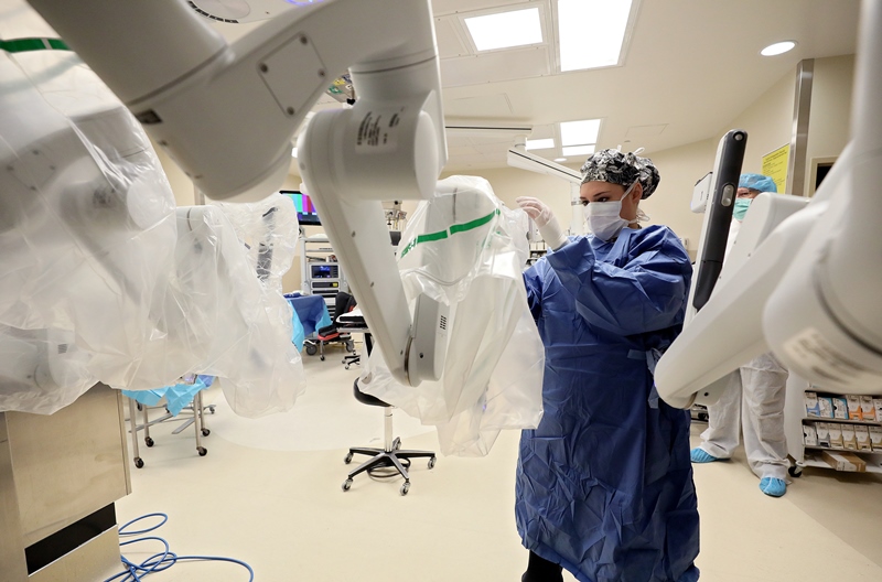 Specialist preparing Da Vinci robotic machine for surgery