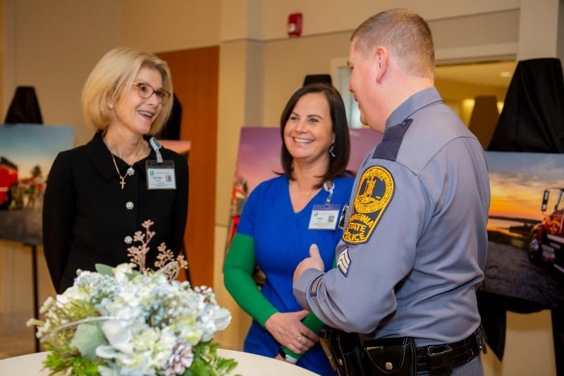 Police officer laughing with hospital staff at art exhibit