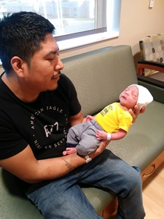 father Reymundo holding his newborn baby Joseu