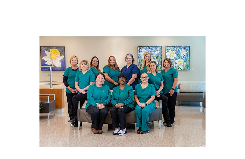 Team of nurses smiling in green scrubs