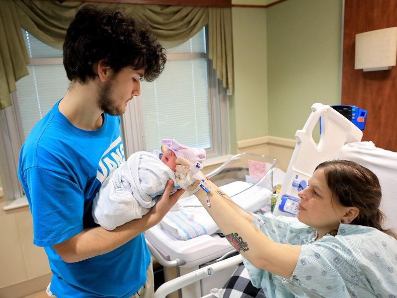 New parents Ethan and Teresa holding their newborn