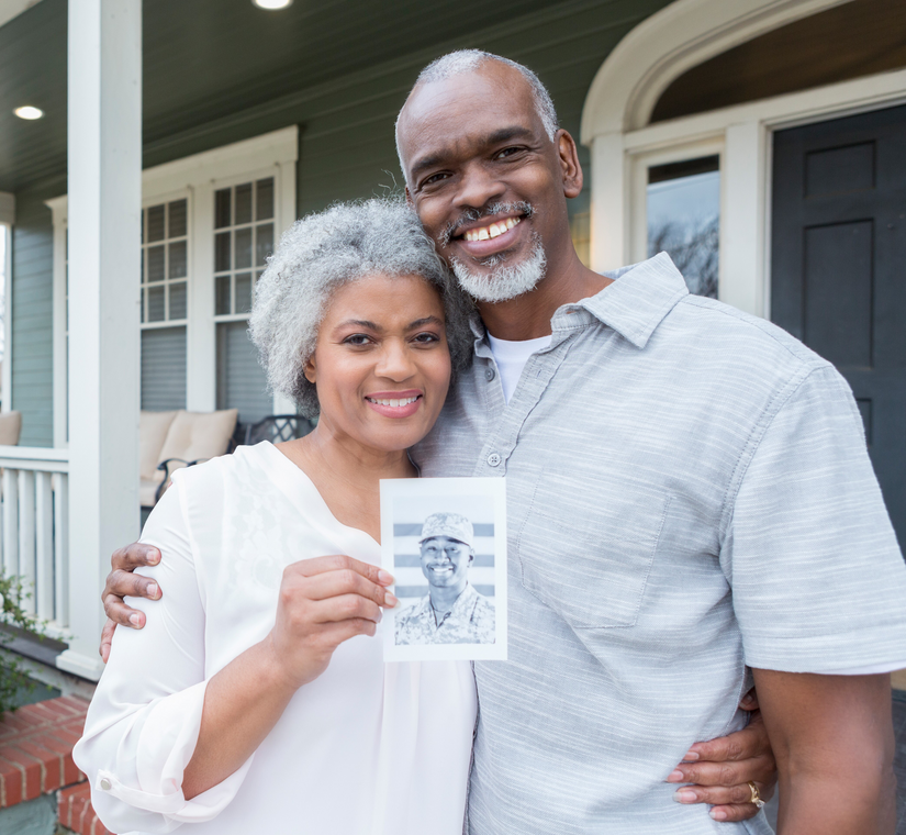 2 people holding a picture of military veterans