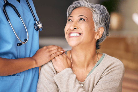 Nurse, senior woman and smile with comfort, holding hands or support in nursing home for retirement. Doctor, medic or caregiver with kindness, empathy or gratitude for help, trust or service in house