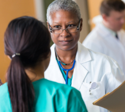 Senior African American female doctor talking with nurse in hospital