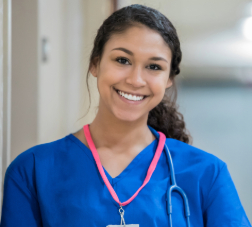 Beautiful young adult nurse standing in modern hospital hallway