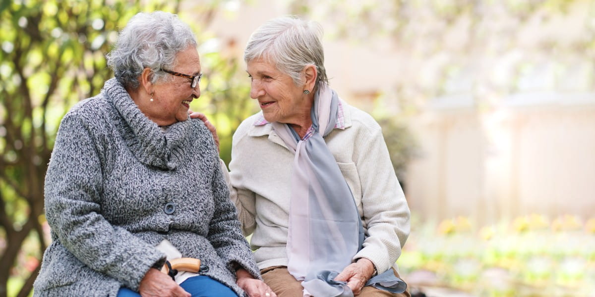 elderly women sitting on a park bench